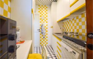 une petite cuisine avec des carreaux à carreaux jaunes et blancs dans l'établissement Cozy Apartment In Lido Di Camaiore, à Lido di Camaiore