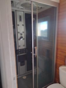 a glass shower in a bathroom with a toilet at Casa container in Mar del Plata