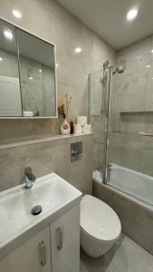 a bathroom with a sink and a toilet and a shower at Double room with garden view in London