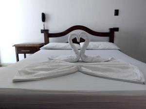 Una cama con dos toallas blancas formando un corazón en Hotel Soliari Melgar, en Melgar