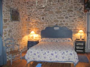 - une chambre avec un lit et un mur en pierre dans l'établissement Chambres d'Hôtes Gelous, à Bidache
