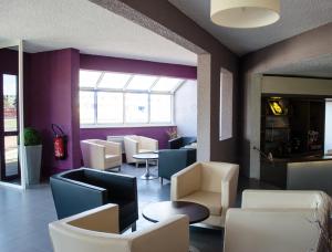 a restaurant with white chairs and tables and a purple wall at HECO Calais Centre-Gare in Calais