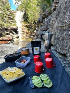 a table with plates of food and red cups at Chalés Canto da Graúna in Ibicoara +47 photos