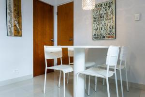 a white table and white chairs in a room at 103-Delightful GEM in the city, Close to the Beach with Free Parking in San Juan