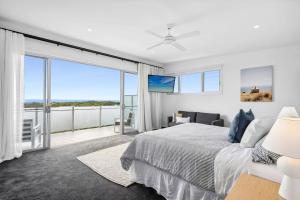 a bedroom with a bed and a large window at Beautiful Three-Story Villa footsteps to the Beach in Coolum Beach
