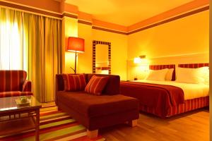 a hotel room with a bed and a couch at Pestana Sintra Golf Resort & SPA Hotel in Sintra
