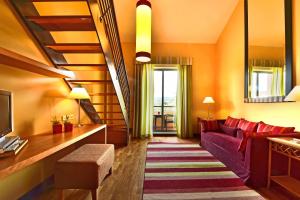 a living room with a purple couch and a tv at Pestana Sintra Golf Resort & SPA Hotel in Sintra