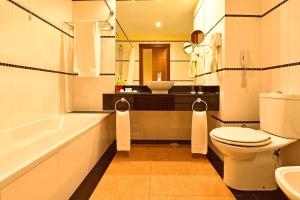 a bathroom with a tub and a toilet and a sink at Pestana Sintra Golf Resort & SPA Hotel in Sintra