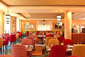 a restaurant with red chairs and tables in a room at Pestana Sintra Golf Resort & SPA Hotel in Sintra