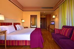 een hotelkamer met een groot bed en een bank bij Pestana Sintra Golf Resort & SPA Hotel in Sintra