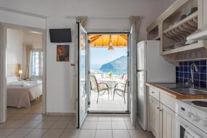 a kitchen with a view of a table and a dining room at Thea Home Hotel in Skopelos Town