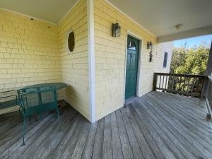 a front porch of a house with a green door at ISLAND DREAMING RETREAT cottage in Frisco