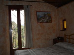1 dormitorio con cama y ventana grande en Lo Scoiattolo, en Ventimiglia