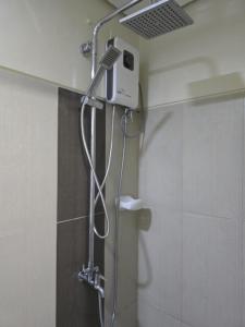 a shower in a bathroom with a shower head at Rhoydez Condotel Breeze Residence in Manila