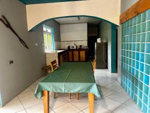 a kitchen with a table with a green table cloth on it at Pension Villa TEKO in Nuku Hiva