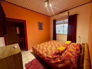 een slaapkamer met een bed in de hoek van een kamer bij Pension Villa TEKO in Nuku Hiva