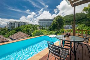 a patio with a table and chairs next to a swimming pool at Prima Villas Karon Phuket in Karon Beach