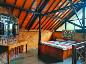 una camera da letto con un letto e una scrivania in una stanza di Yoschi's Hotel Bromo a Ngadisari