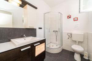 a bathroom with a sink and a toilet and a shower at Family friendly seaside apartments Iz, Iz - 22025 in Veli Iž +18 photos
