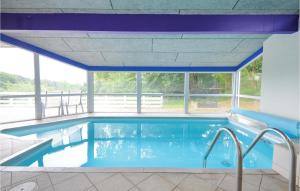 a large swimming pool with a large window at Awesome Home In Ebeltoft With Sauna in Ebeltoft