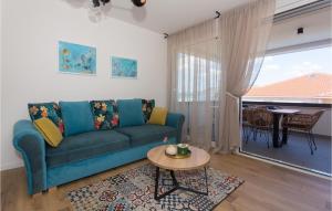 a living room with a blue couch and a table at Gorgeous Apartment In Okrug Gornji in Trogir