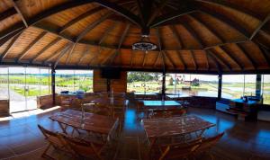 a restaurant with wooden tables and chairs and windows at Quinta da Soliran Chalés Rural in Cambará