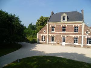 a large red brick building with a driveway at Les 3 Tilleuls in Roye