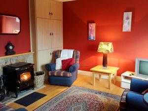 a living room with a chair and a fireplace at Cottage 188 - Ballyconneely in Ballyconneely