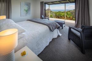 a bedroom with a bed and a large window at The Lighthouse Lookout in Tutukaka