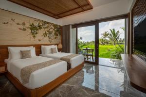 a bedroom with two beds and a balcony at Emana Akatara in Ubud