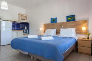 a bedroom with a large blue bed with towels on it at Thea Home Hotel by Booking Kottas in Skopelos Town +50 photos