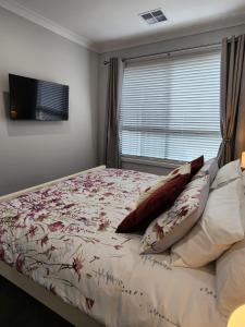 a bedroom with a bed with pillows and a window at Holiday at the Beach, Spa Bath, King Bed with TV in Christies Beach