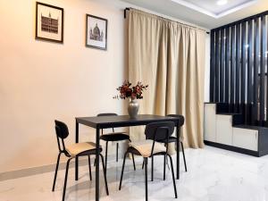 a dining room with a black table and chairs at PRIVATE Luxury Homestay in Khammam in Khammam