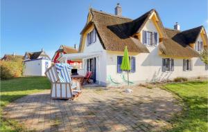 ツィローにあるCozy Home In Zierow Ot Poeler Driftの芝生の椅子2脚と傘1脚の家