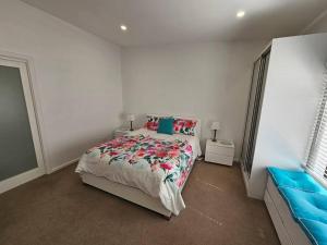 Blossom Cottage - Cosy Retreat في Penna: غرفة نوم بيضاء بسرير واريكة زرقاء