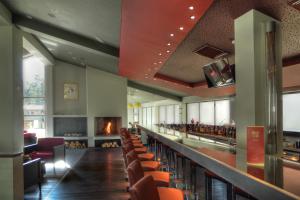 a room with a bar with chairs and a fireplace at Euphoria Club Hotel in Borovets