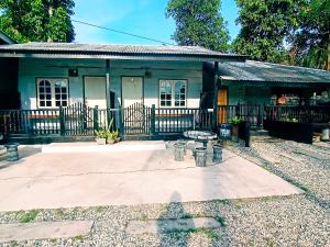 a small house with a fence in front of it at Tamu Chalet Cherating in Kuantan