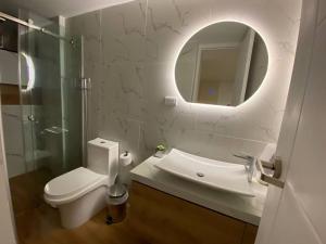 a bathroom with a toilet and a sink and a mirror at Moderno Apartamento Centro Tacna in Tacna