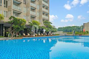 ein großes Schwimmbad vor einem Gebäude in der Unterkunft Angsana by Kozystay - Paskal in Bandung