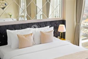 ein Schlafzimmer mit einem großen weißen Bett mit weißen Kissen in der Unterkunft Angsana by Kozystay - Paskal in Bandung + 29 Fotos
