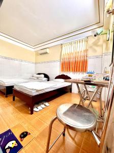 a room with two beds and a table and a chair at Khách Sạn Ngọc Cường in Bạc Liêu