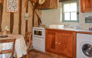 a kitchen with a table and a sink and a dishwasher at Nice Home In Église-Neuve-D'issac in Saint-Jean-dʼEyraud