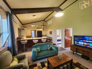 a living room with a blue couch and a kitchen at The Church House- Boutique Comfort in Balclutha