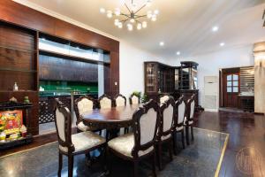 Un comedor con mesa y sillas de madera. en KN 5 Villa - Venuestay, en Ho Chi Minh