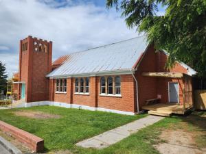 a red brick building with a clock tower at The Church House- Boutique Comfort in Balclutha