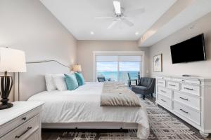 a white bedroom with a bed and a tv at Kasa 539 Bay Street Traverse City in Traverse City +17 photos