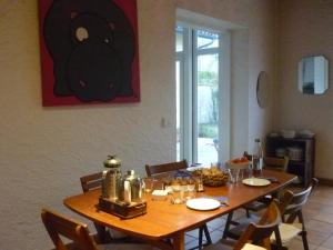 a wooden table in a dining room with chairs and a tableablish at La landaise in Laluque