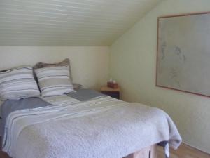 a bedroom with a bed with white sheets and pillows at La landaise in Laluque
