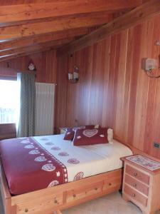 ein Schlafzimmer mit einem Bett in einer Holzwand in der Unterkunft Maison Gaudenzio in Challand Saint Anselme