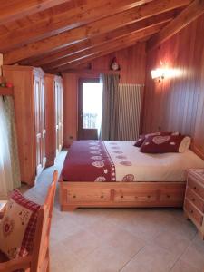 ein Schlafzimmer mit einem Bett in einem Zimmer mit Holzwänden in der Unterkunft Maison Gaudenzio in Challand Saint Anselme